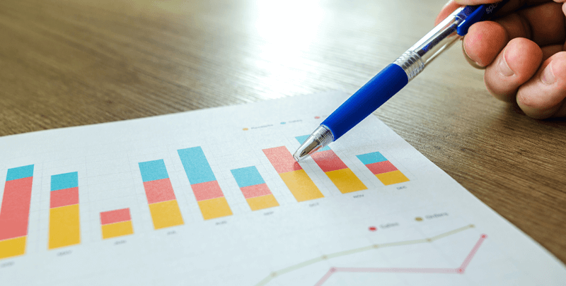 Relatórios financeiros e análises de dados em planilha com gráfico de barras colorido para tomada de decisão empresarial.