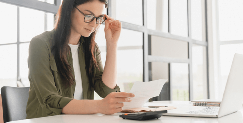 Gestora analisando documentos fiscais e dados tributários em ambiente de escritório para soluções fiscais e contábeis com Dootax.