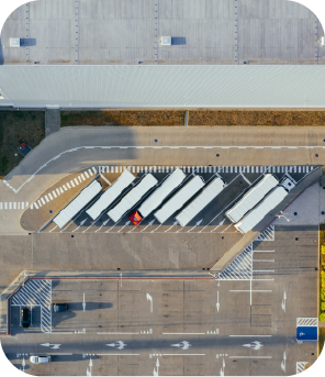 Estacionamento de caminhões na área de logística da Dootax, com espaço para várias cargas e gestão eficiente de transporte de cargas e fretamento de veículos.