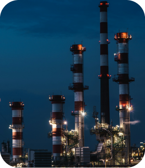 Fábrica de energia com chaminés industriais em operação ao anoitecer, destaque para inovação e eficiência industrial.