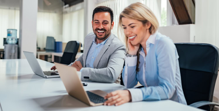 Profissionais de negócios discutindo estratégias de gestão financeira com laptops em escritório moderno.