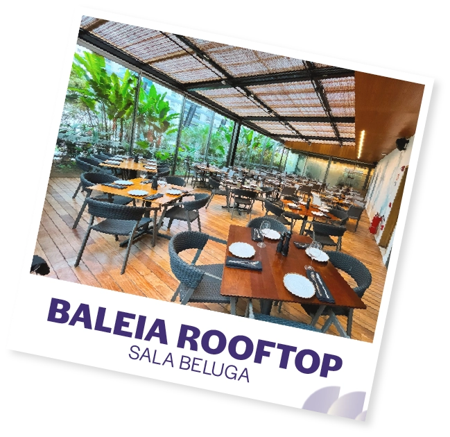 Churrasqueira no rooftop do Baleia Rooftop Sala Beluga com vista para o jardim tropical ao ar livre. Ambiente elegante e confortável para refeições e eventos ao ar livre em um espaço moderno e bem dec.